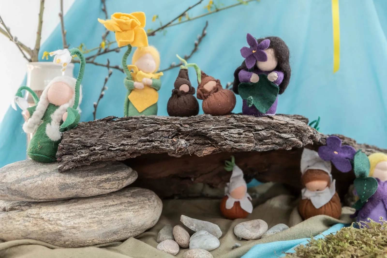 Ručně vyrobené figurky z vlny na kůře a kamenech ve waldorfské škole.